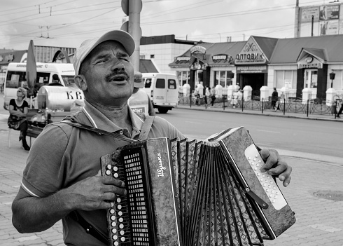 Ufa, Russia - July 16, 2014: Faced with his disability this blind accordian player plays music for shoppers in Sterlitamak Russia in the hope of making money
