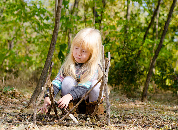 istock Serious Blond Girl Assembling Sticks on the Ground 485155278