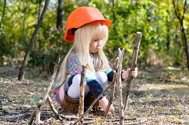 istock Little Girl with Helmet Playing with Sticks 485155288