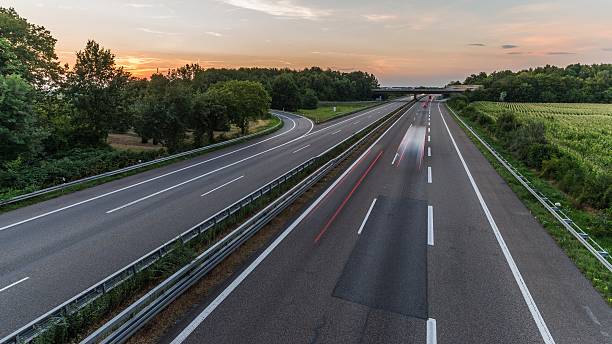 istock german highway at sunset with light trails from passing cars 485158064