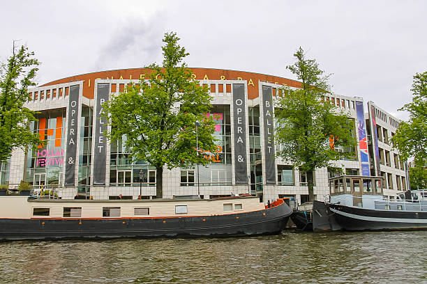 Ships near the building National Opera and Ballet in Amsterdam Amsterdam, Netherlands - June 20, 2015: Embankment and the ships near the building National Opera and Ballet in Amsterdam stopera stock pictures, royalty-free photos & images