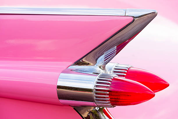 Tail Fin of 1959 Pink Cadillac de Ville Classic Car Geiselwind, Germany - June 20, 2015: Tail fin and rear lights of a 1959 pink Cadillac Coupe de Ville classic car at a vintage American car meeting. Cadillac Motor Car Division, is a division of U.S.-based General Motors. 1959 photos stock pictures, royalty-free photos & images