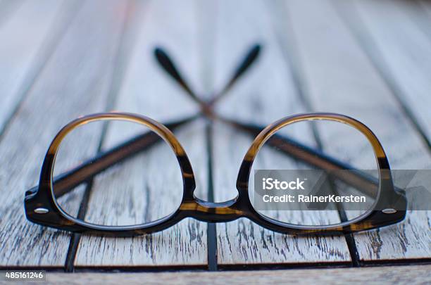 Pair Of Glasses On A Wooden Table Stock Photo - Download Image Now - Eyeglasses, Eyewear, Picture Frame