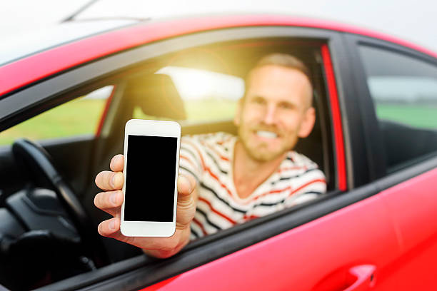 istock Man in car showing smart phone 485163600