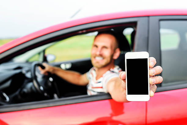 istock Man in car showing smart phone 485163614