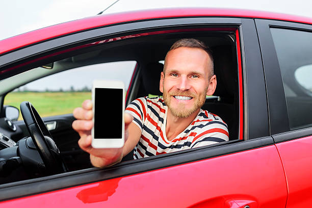 istock Man in car showing smart phone 485163616