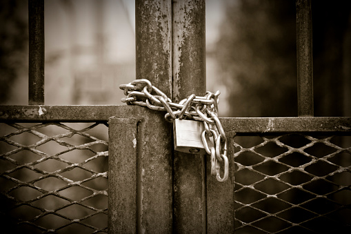 Padlock with rusty chain - sepia toned - concept image