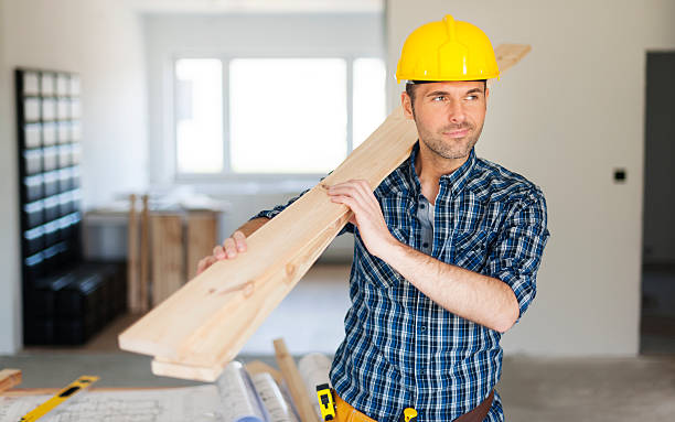 Manley construction worker holding wood planks
