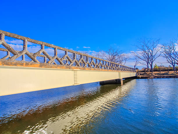istock Wooden bridge in a park with blue water and sky 485169329