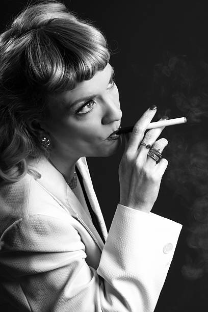 sérieux femme de style des années 1940 bœuf sur e-cigarette. - smoking women smoking issues mature adult photos et images de collection