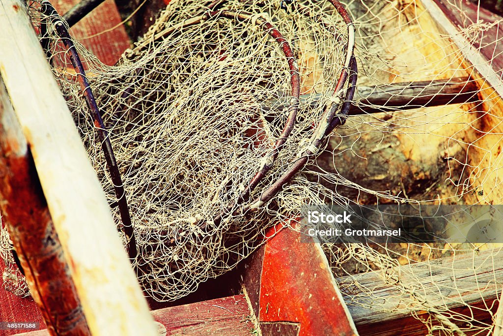 Fishing tackles in old wooden boat taken closeup. Fishing tackles in old wooden boat taken closeup.Toned image. 2015 Stock Photo