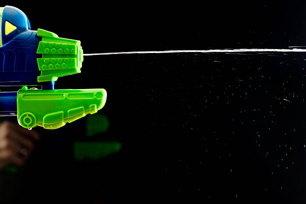 water squirt pistol gun shootinh water on black
