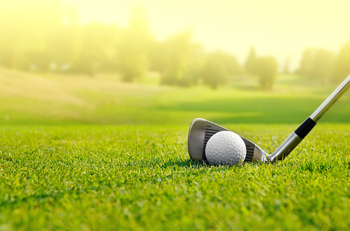 White golf ball on green background. Horizontal composition.