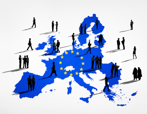 Blue Cartography Of The EU In A White Background And Silhouettes Of Business People On It