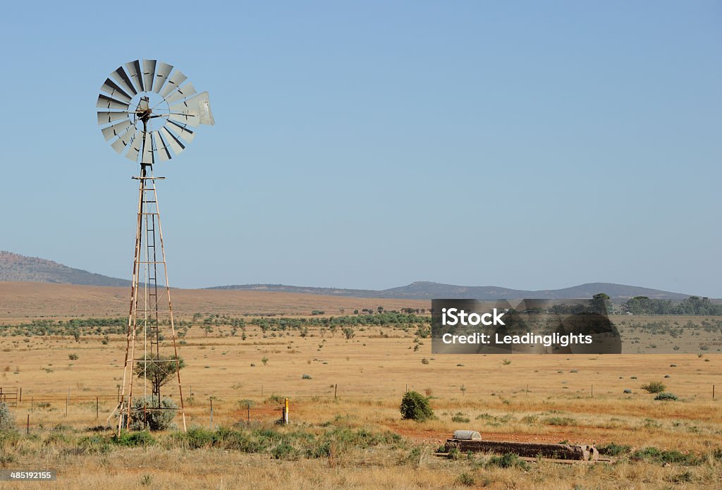 Windpump in the Outback A wind-powered waterpump in the South Australian Outback near the town of Hawker, farm in the distance Farm Stock Photo