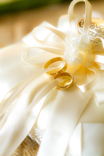 istock Two gold wedding rings and fresh white lilly. Shallow DOF. 485193219