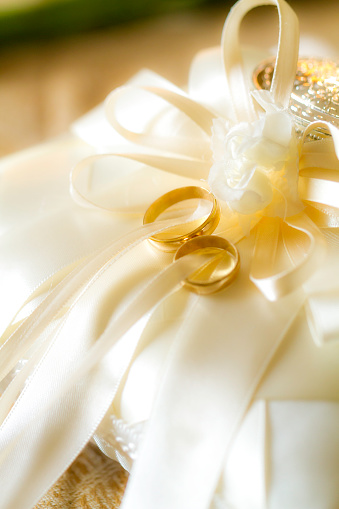 Two gold wedding rings and fresh white lilly. Shallow DOF.