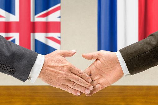 Representatives of the UK and France shake hands