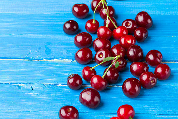 istock Cherries on a blue wooden background 485197716