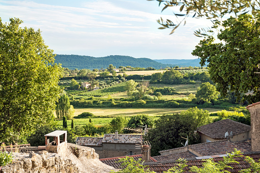 View over the roofs of an old village in the landscape of Provence, Cucuron, France, Luberon region