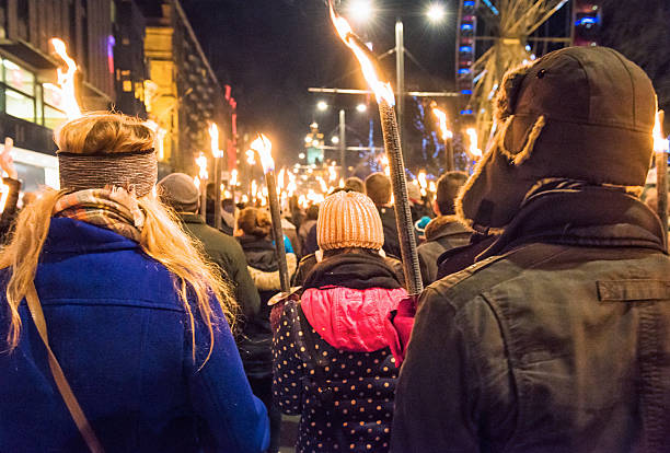 Hogmanay Torchlit Procession in Edinburgh, Scotland Edinburgh, UK - December 30, 2014: Crowds of people carrying flaming torches along Princes Street in central Edinburgh, part of the city's annual celebrations around New Year, or Hogmanay. hogmanay photos stock pictures, royalty-free photos & images