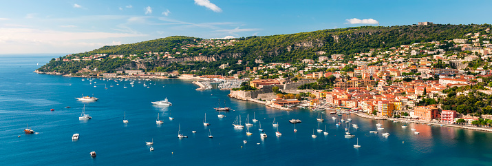 Panoramic aerial view of French Riviera coast at Villefranche-sur-Mer harbour and Cap de Nice with leisure boats anchored at Mediterranean sea