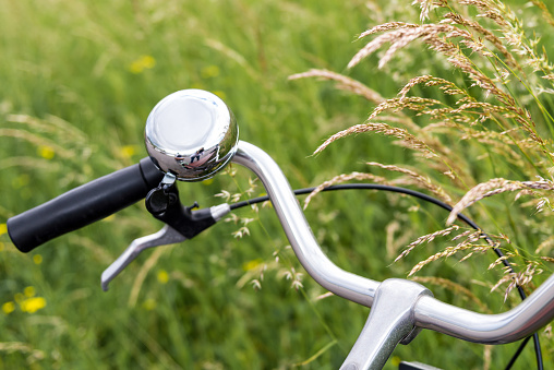A close-up of a bicycle bell and a handlebar on a park in Copenhagen, Denmark