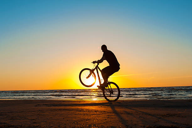 istock Man cyclist silhouette on blue sky and multicolored sunset backgorund. 485209688