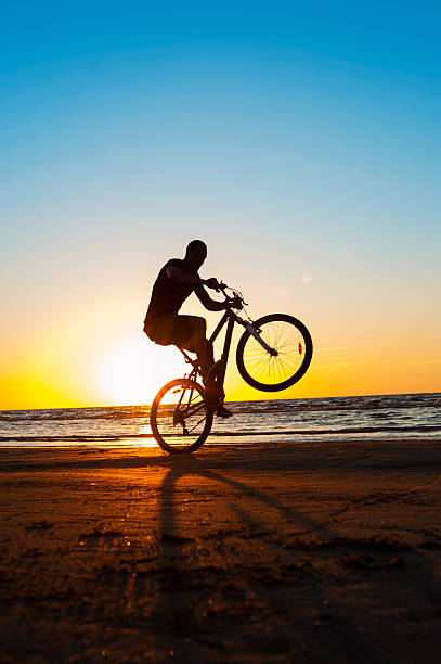 istock Man cyclist silhouette on blue sky and multicolored sunset background. 485209698