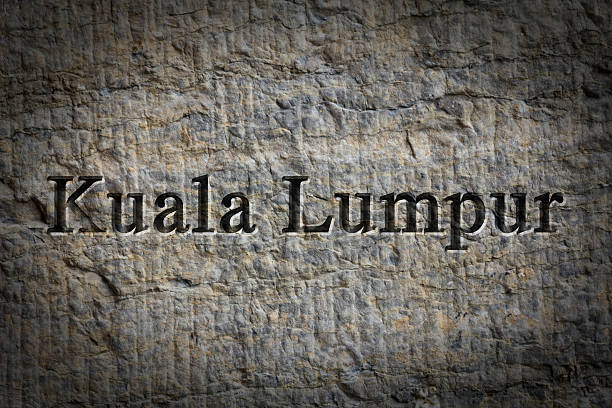 Engraving spelling the city Kuala Lumpur on textured old surface