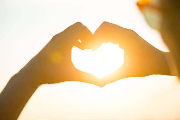 istock Heart shape with hands against the sun at dust 485220724