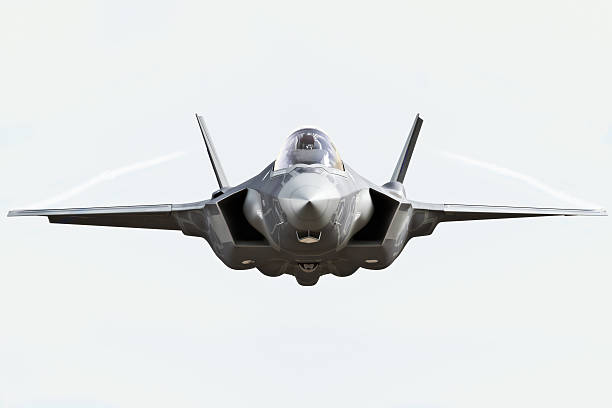 F35 front view close up F35 front view close up flying to the camera with chem trails fighter plane stock pictures, royalty-free photos & images
