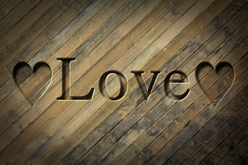 Engraving spelling the word Love on textured old surface