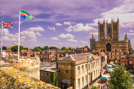 Lincoln, Lincoln, England. Saturday 15 August 2015. Panoramic view of the west side of Lincoln Cathedral and Lincoln City taken from the top of Lincoln Castle on a sunny afternoon. The Judges Lodgings and Castle square can be seen in the foreground along with the bustling market.