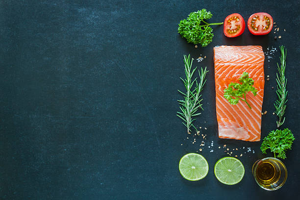 istock Salmon fillet with garnish on blackboard 485242160