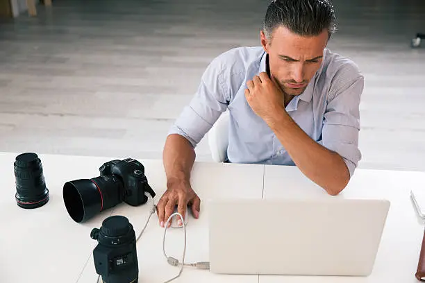 Photo of Photographer using laptop