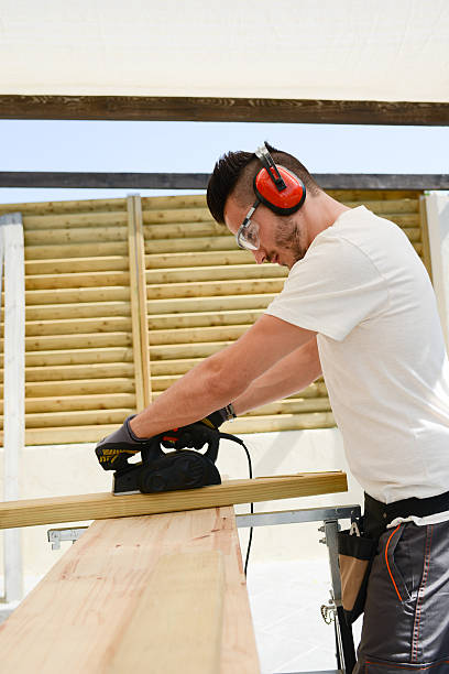 istock young man carpenter working outdoor wood timber in construction site 485249198