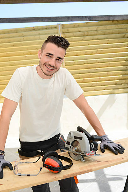 istock young man carpenter working outdoor wood timber in construction site 485250438