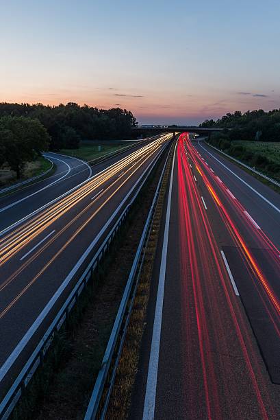 istock german highway at sunset with light trails from passing cars 485250942