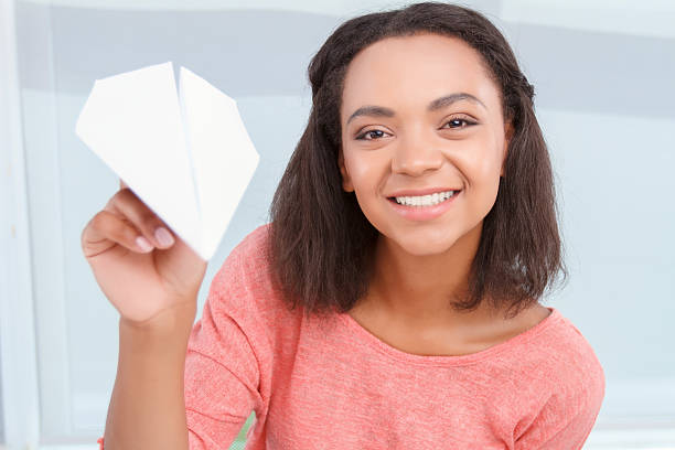 istock Smiling girl throwing paper plain 485251192