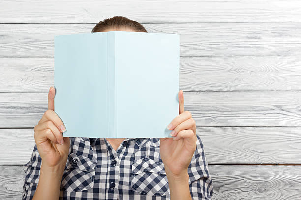 istock Woman reading a book and covering her face 485252036