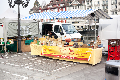 Lucerne, Switzerland - March 11, 2014: A man sets up his booth in Lucerne, Switzerland. The man can be seen getting his goods ready and setting up his station at a market in Lucerne, Switzerland on an early spring day