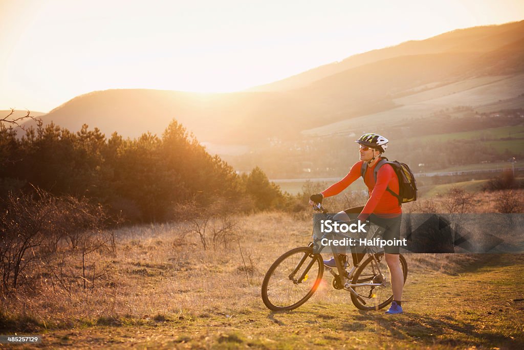 Mountain biker Cyclist man riding mountain bike on outdoor trail in sunny meadow Activity Stock Photo