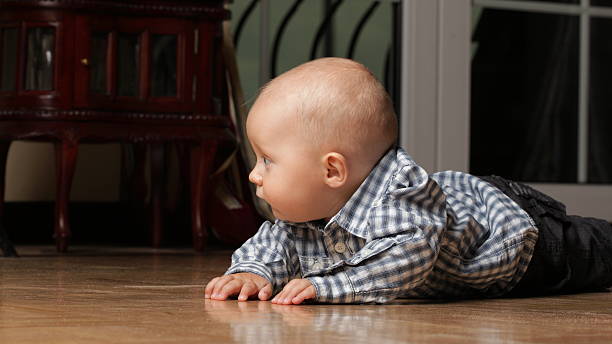 istock 6 months male child sitting on floor 485257265