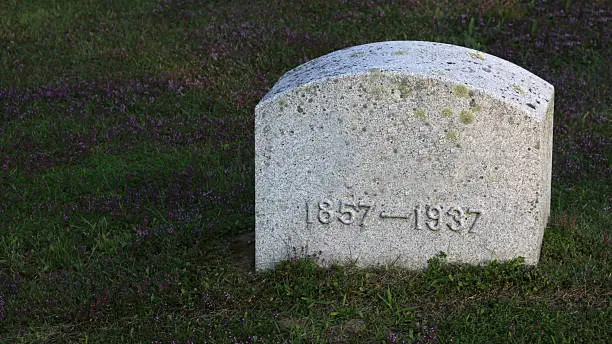 A large gravestone with years 1857-1937 (80 years) in a graveyard.