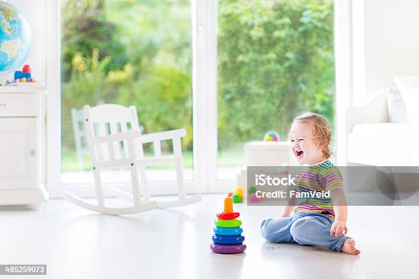 Happy Laughing Toddler Girl Playing In Room With Big Window Stock Photo - Download Image Now