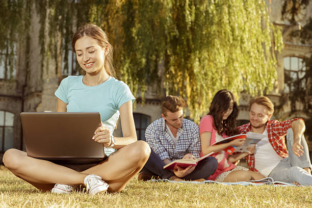 istock Group of beautiful young student sitting on the grass 485261318
