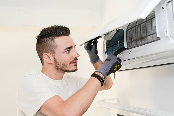 istock handsome young man electrician installing air conditioning in client house 485266260
