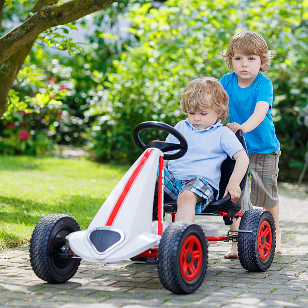 istock Two happy sibling boys having fun with toy car 485271902