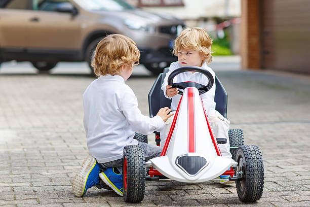 istock Two happy sibling boys playing with toy car 485271956